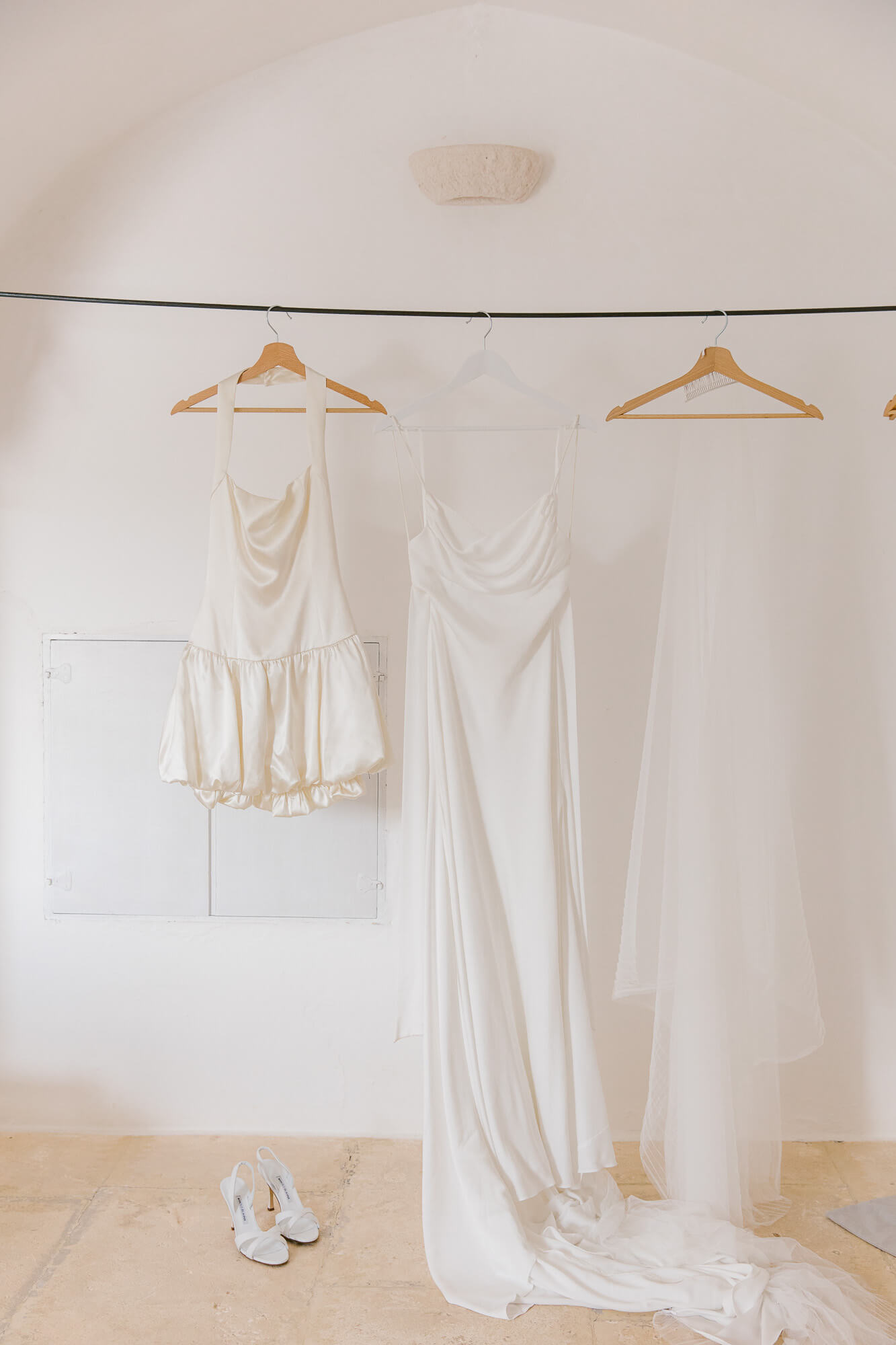Wedding dress hanging in a white room