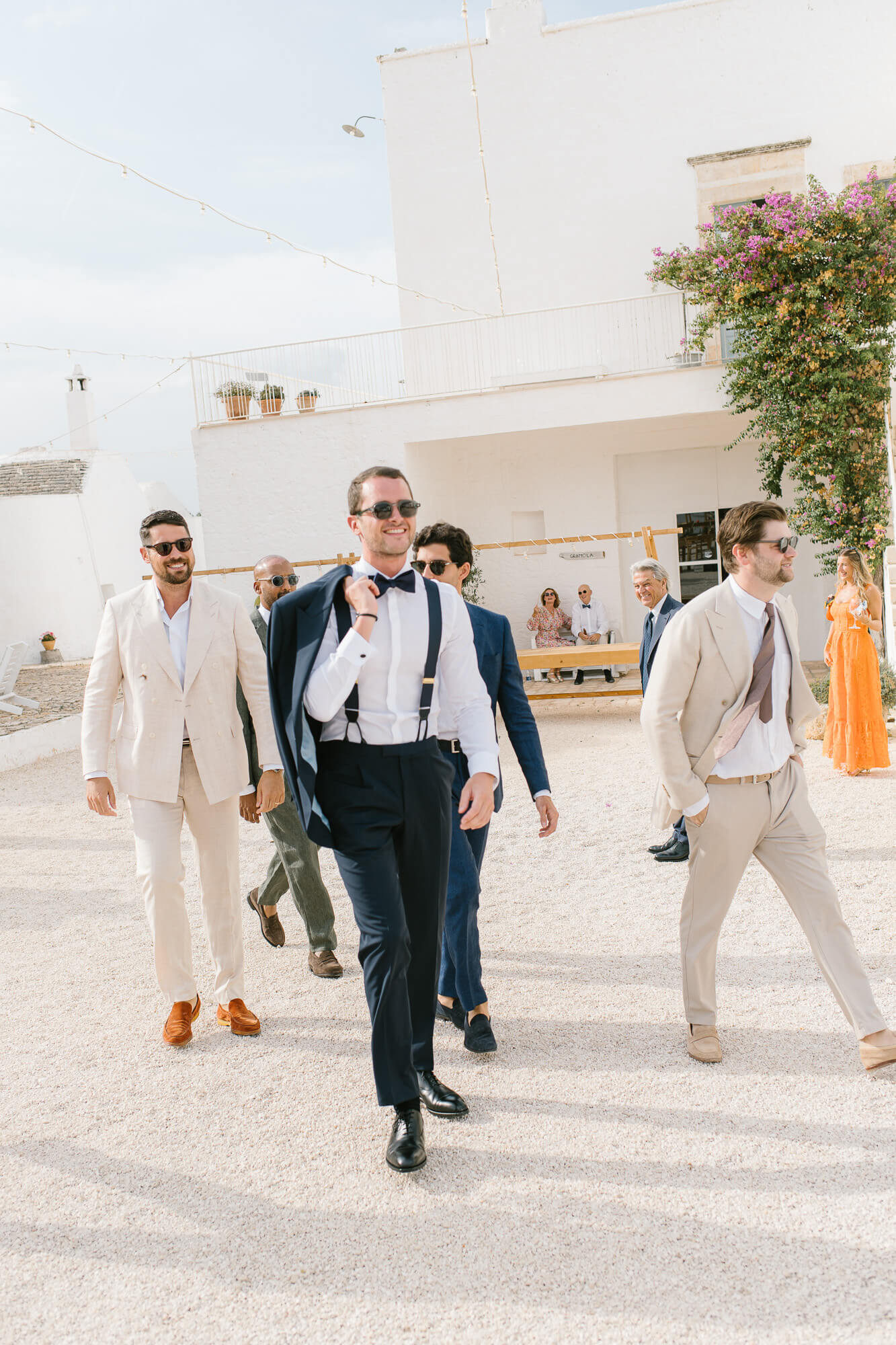 Groomsmen walking across the masseria courtyard