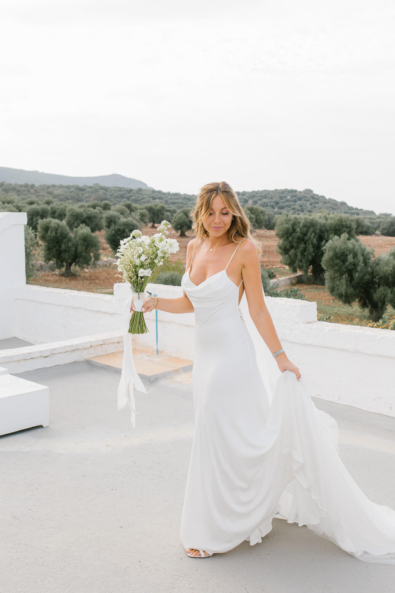 Bride walking on the terrace with her wildflower bouquet