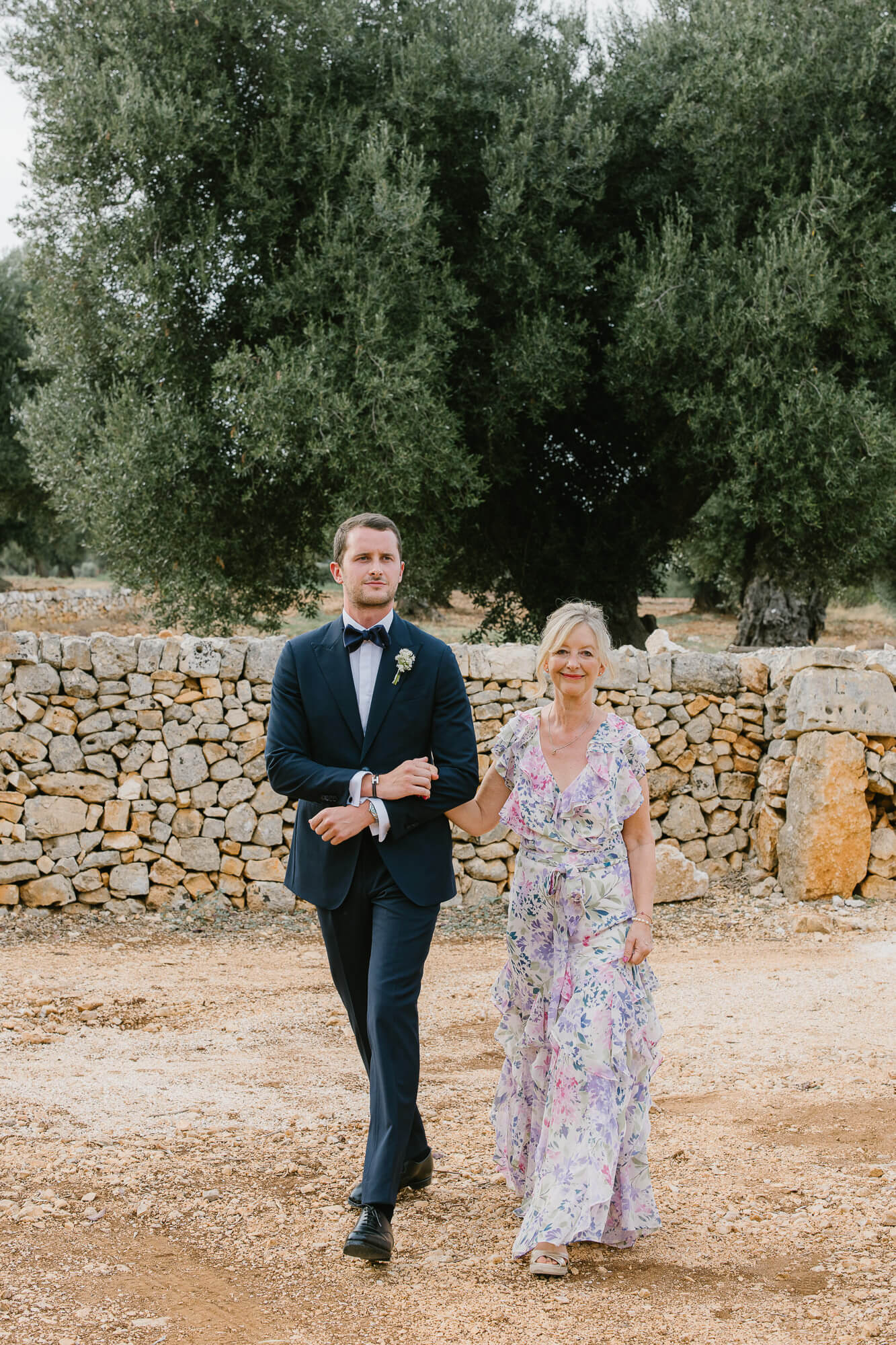 Groom walking to the ceremony with his mother