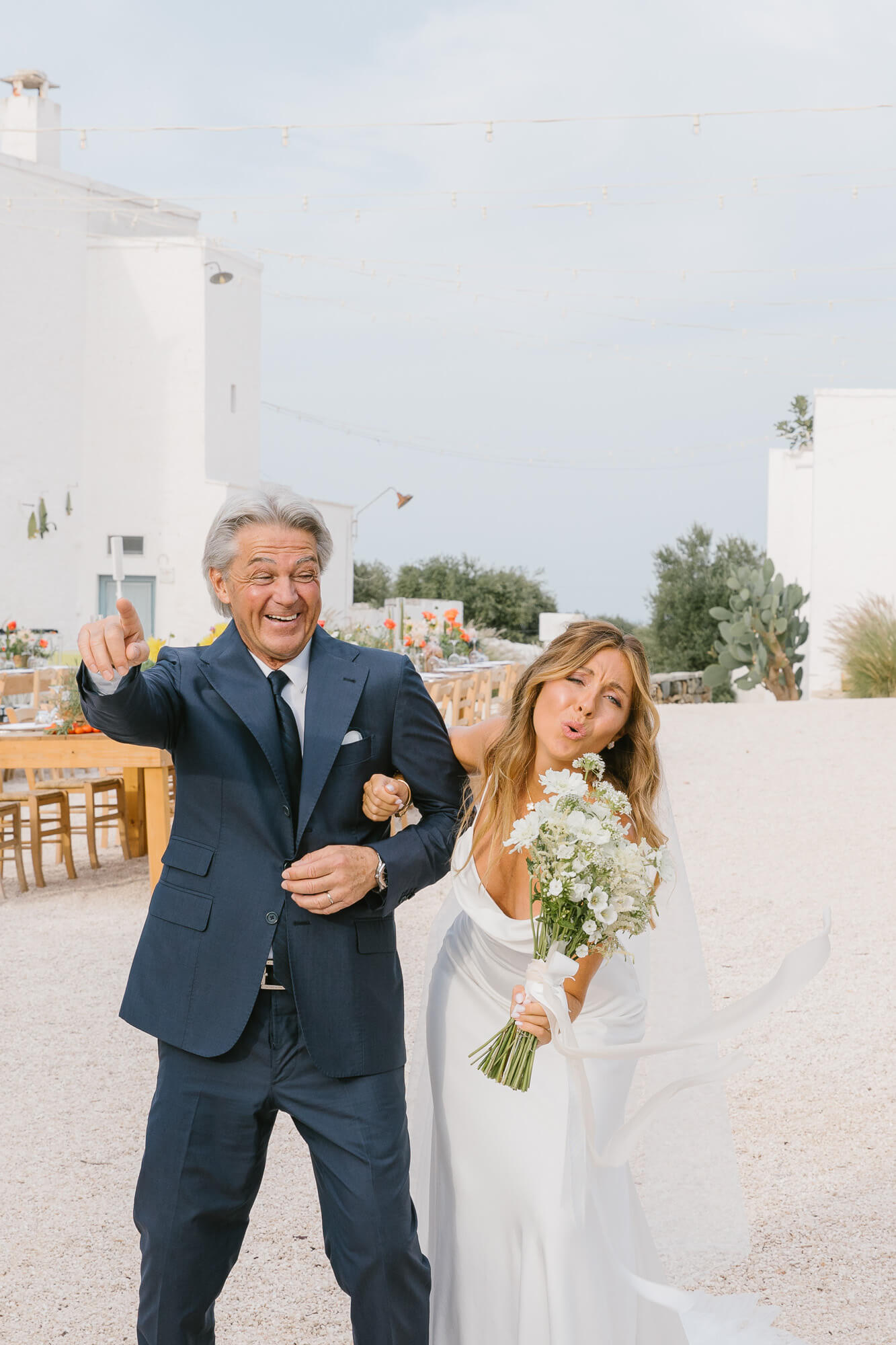 Father of the bride waving as he walks her to the ceremony