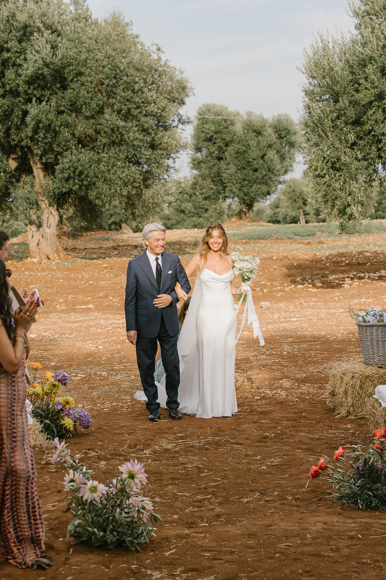 Bride and her father walking down the olive grove aisle