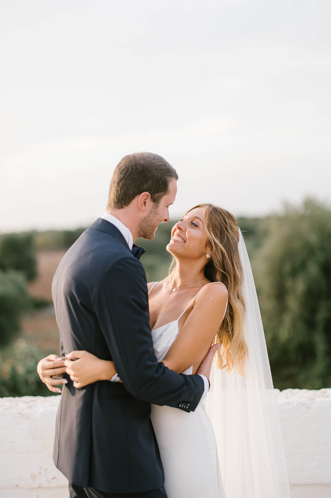 Bride and groom at sunset above the olive groves of Puglia