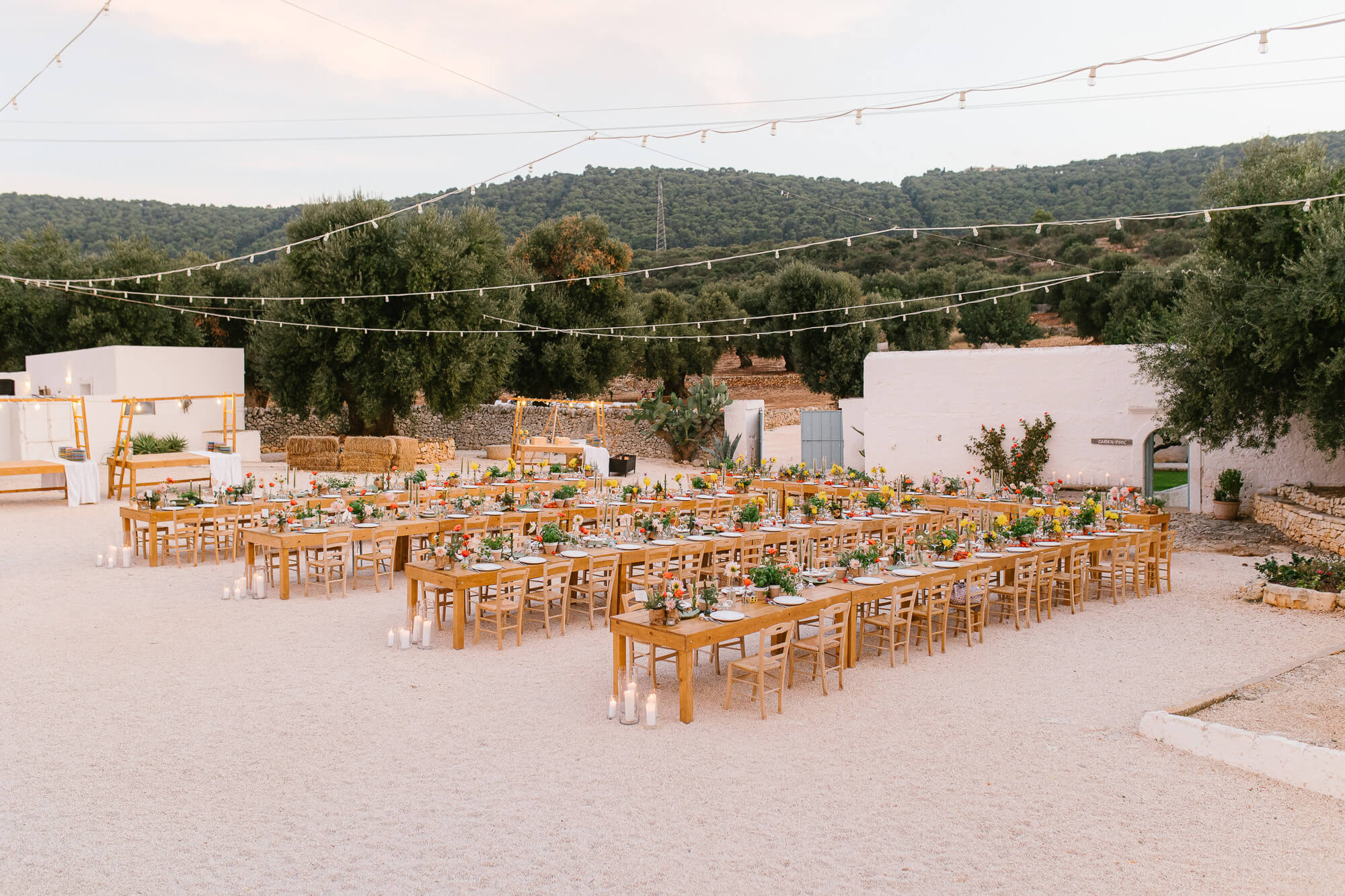 Wedding dinner tables under string lights at Masseria Mozzone