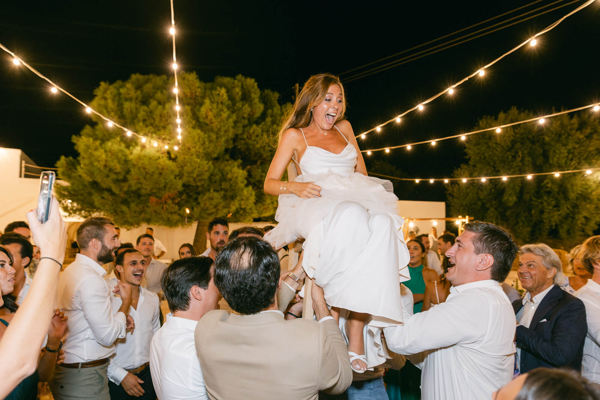 Bride lifted by guests on the dance floor