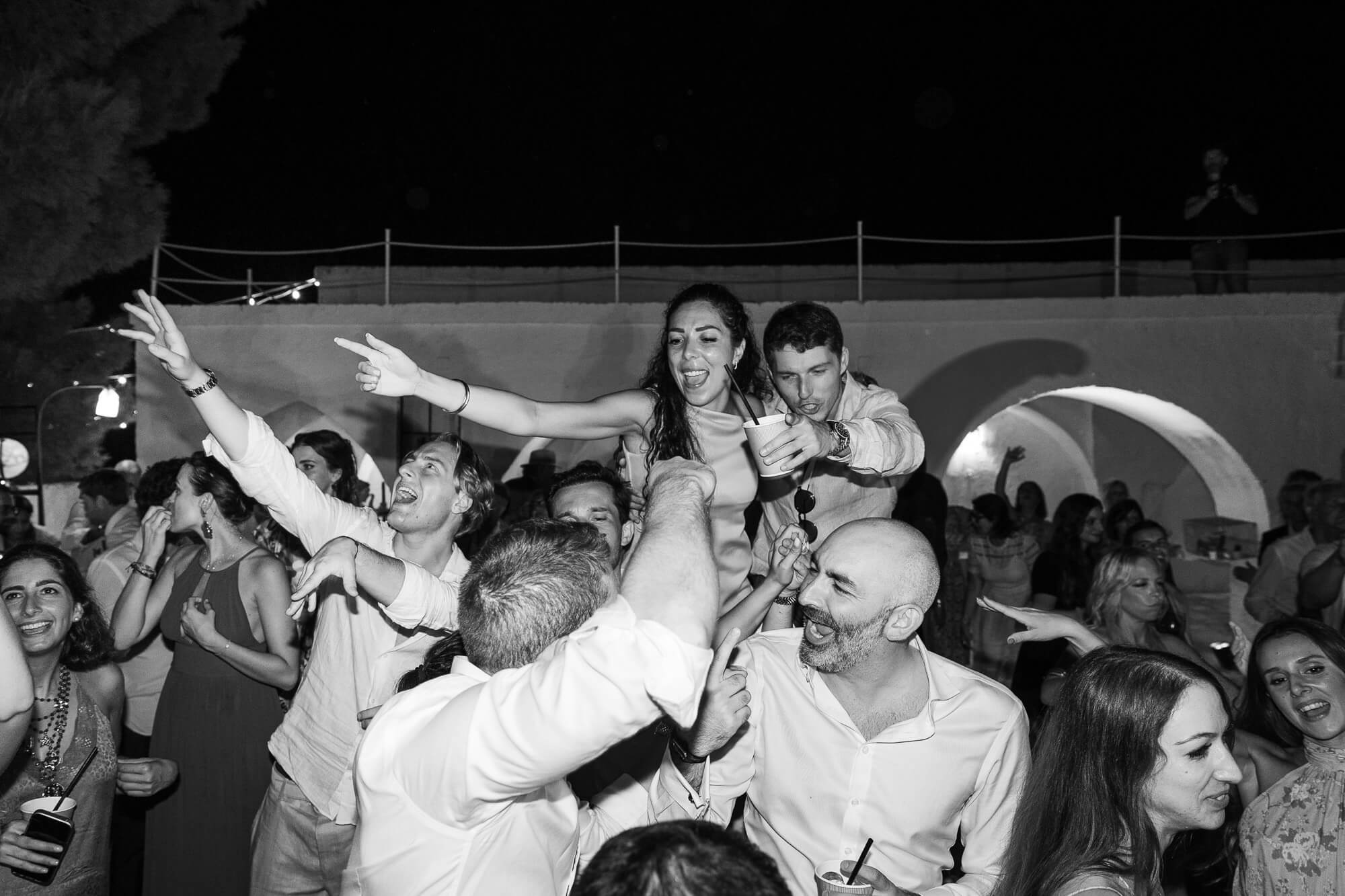 Guests lifting the groom on the dance floor