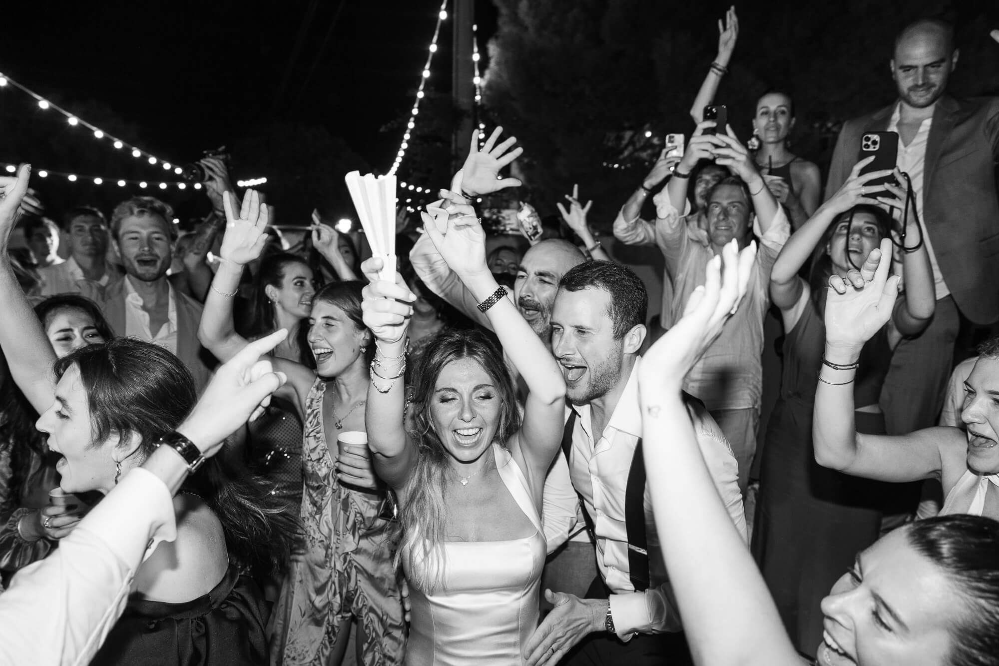 Wedding party crowd dancing under the lights
