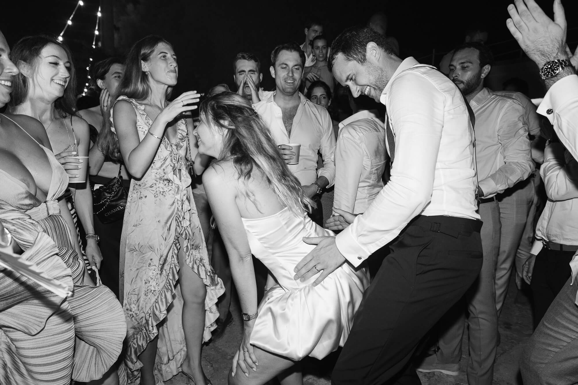 Groom dancing with guests late at night