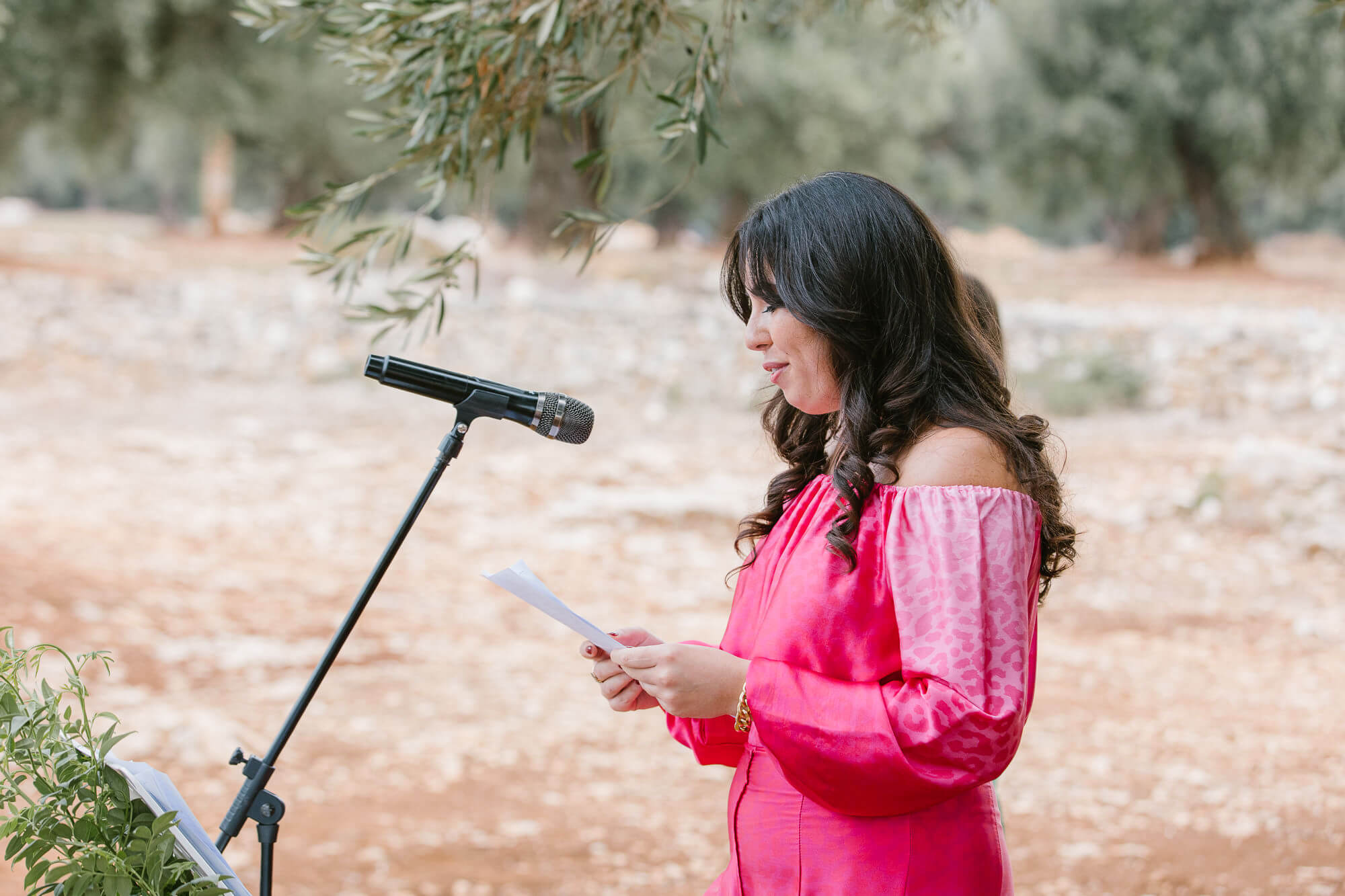 Friend in pink reading at the wedding ceremony
